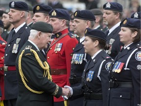 Governor General David Johnston shakes hands with police officers who served in Afghanistan during a National Day of Honour as he inspects the guard May 9 in Ottawa.