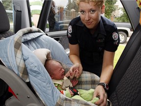 A file photo showing an officer putting a baby in a carseat.