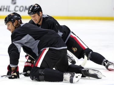 Erik Karlsson, left, and Marc Methot of the Ottawa Senators stretch during morning skate at the Canadian Tire Centre.