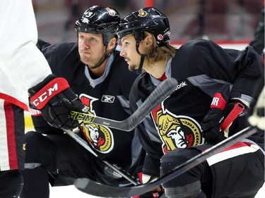 Erik Karlsson, right, and Marc Methot of the Ottawa Senators stretch during morning skate at the Canadian Tire Centre.