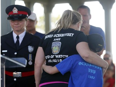 Erin Ochakovsky and her son Owen, age 8, hug each other after speaking during a ceremony behind Parliament Hill in Ottawa, Saturday, September 27, 2014. Erin, who lost her husband James in an on-duty car crash in 2010, and Owen, joined police officers for the final leg of the 460km National Peace Officers Memorial Run as it passed Ottawa Police headquarters then up Elgin to Parliament Hill.
