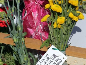 Flowers and a note are attached to a cycling water bottle beside the ghost bike. A ghost bike has been placed on River Road just outside of Manotick — at the site of the accident that killed Laurie Strano during Saturday's Ride the Rideau.