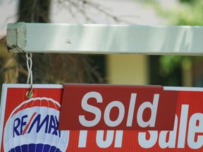 A house "sold" sign in Oakville, Ont., Monday, July 23, 2012. The Canadian Real Estate Association says national home sales edged down 1.7 per cent month over month in November and were back where they stood in August.