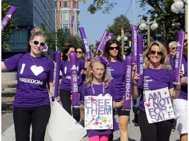 Freedom Walk participants (L-R) Kandace Doiron, Hannah Brown, age 9, and her mother Tamara walk south on Elgin St. in downtown Ottawa, Saturday, September 27, 2014. Anti-human trafficking organizations are celebrating their fifth annual Freedom Walk, but first in Ottawa. They raise funds and hope to increase awareness to fight human trafficking, a growing problem in Canada (and around the world). Mike Carroccetto / Ottawa Citizen