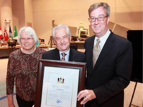 Bill Robinson receives his Mayor's City Builder Award, flanked by Mayor Jim Watson and Coun. Marianne Wilkinson.