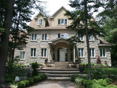 Nestled among the trees on a two-acre lot in Kanata, this three-storey home was built in 2001 by Jim McGill Custom Homes. It includes an in-law suite over the garage, large foyer, wainscoting up to the third floor, beautiful colonial mouldings and baseboards and a Laurysen kitchen with classic white cabinetry and black countertops.