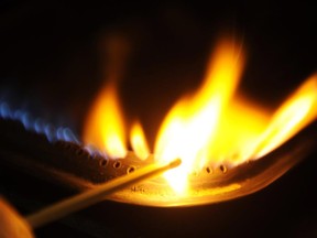 A man lights a natural gas stove.