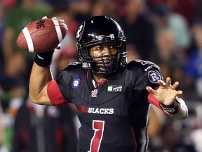 Henry Burris of the Ottawa Redblacks manages to throw the football as his leg is being tackled by Jabar Westerman of the BC Lions during first half action at TD Place in Ottawa, September 5, 2014.