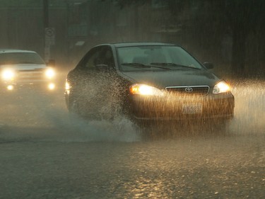A car drives on Bronson Ave. as a thunderstorm passes through Ottawa on the afternoon of Friday, September 5, 2014.