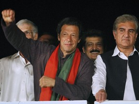 Pakistan's cricketer-turned-politician Imran Khan, left, raises his arm before his supporters as his party leader Shah Mahmood Qureshi, right, looks on during a protest in Islamabad, Pakistan, Wednesday, Sept. 3, 2014.