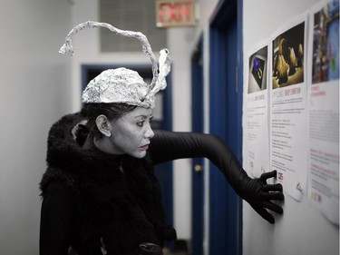 Jacqui Du Toit reads a poster at the Ottawa School of Art, while wearing her alien people performance during Nuit Blanche in Ottawa, on Saturday, September 20, 2014.