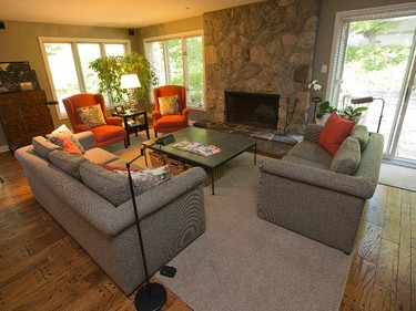 In the family room, simple couches sit beside a massive stone fireplace.