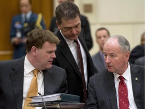 Foreign Affairs Minister John Baird (left) speaks with Defence Minister Rob Nicholson as David Anderson (centre), Parliamentary Secretary to the Minister of Foreign Affairs, listens as they wait to appear before the House Foreign Affairs and International Development committee Tuesday.