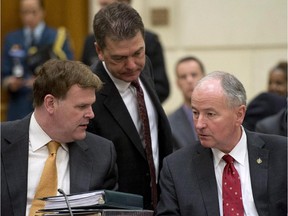 Foreign Affairs Minister John Baird (left) speaks with Defence Minister Rob Nicholson as David Anderson (centre), Parliamentary Secretary to the Minister of Foreign Affairs, listens as they wait to appear before the House Foreign Affairs and International Development committee on Parliament Hill in Ottawa Tuesday, September 9, 2014.