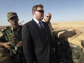 Canadian Foreign Affairs Minister John Baird, centre, and Iraqi Deputy Minister Rowsch Nouri Sharways look at the ISIS positions from a front line bunker Thursday, September 4, 2014 in Kalak, Iraq.