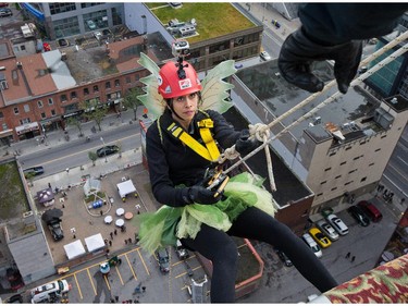 Kalpana Phansalker steps over the edge as participants rappel from the top of the Morguard Building at 280 Slater Street in the 5th annual Drop Zone Ottawa event which raises money for Easter Seals. September 22, 2014.