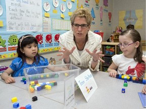 Ontario Liberal leader Kathleen Wynne sits with school children during a campaign stop in Markham, Ontario on May 28, 2014.
