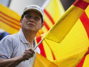 Kien Nguyen flies the Freedom Flag of Vietnam during a demonstration over the city of Ottawa's decision to fly the communist flag of Vietnam to mark the country's day of independence. The protesters would like to see the city honour the Freedom Flag of Vietnam.