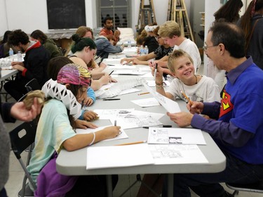 Kristof Watkins, 9, looks to Gerard Belec as they draw comics at Ottawa School of Artduring Nuit Blanche in Ottawa, on Saturday, September 20, 2014.