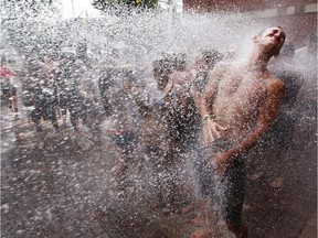 Louis-Felix Brisson, right, a first year Human Kinetics student takes part in an University of Ottawa Week 101 gets hosed off by Ottawa firefighters at Station 13 during an initiation activity with fellow students after walking hand-in-hand along King Edward Ave Thursday, September 4, 2014. The students were covered in various foods included cat food, ketchup, mustard, soy sauce.