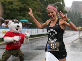 Lyndsay Tessier is the first woman to cross the finish line of the half marathon during the 2014 Canada Army Run held in Ottawa on September 21, 2014.