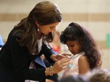 Mary, Crown Princess of Denmark, puts a pin on Rawassy Salem Omar of grade one at the Centennial Public School after Rawassy was sworn in.