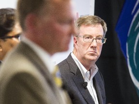 Mayoral candidate Mike Maguire, left, speaks during an all-candidates mayoral debate at the Carleton University Residence Commons while incumbent Jim Watson, right, looks on Tuesday.
