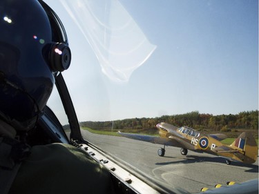 Michael Potter, left, prepares to launch the P-51 Mustang into the sky along with the P40-N Kittyhawk, flown by Rob Erdos, right, en route to escort the Canadian Warplane Heritage Museum's Avro Lancaster to Vintage Wings of Canada in Gatineau, Sept. 27, 2014.