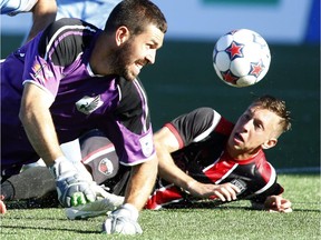 Minnesota United FC goalkeeper Matt VanOekel, left, and Ottawa Fury FC Oliver Minatel watch the ball as it misses the net during the first half of their soccer match at TD Place against Minnesota United FC in Ottawa on Sunday, September 28, 2014.