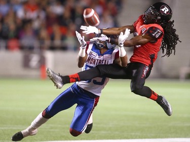 Abdul Kanneh #14 of the Ottawa Redblacks deflects an intended pass to Duron Carter #89 of the Montreal Alouettes during a CFL game at TD Place Stadium on September 26, 2014.