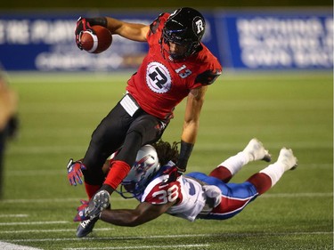 Khalil Paden #13 of the Ottawa Redblacks avoids a tackle by Dominique Ellis #38 of the Montreal Alouettes after a catch during a CFL game at TD Place Stadium on September 26, 2014.