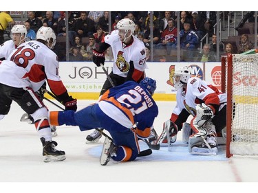 N.Y. Islanders Kyle Okposo takes a spill in front of Ottawa Senators goalie Craig Anderson during first period pre-season NHL action in St. John's, N.L. on Monday September 22, 2014.