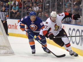 N.Y. Islanders Nikolai Kulemin, left, rounds the net with Ottawa Senators Ben Harpur during first period pre-season NHL action in St. John's, N.L. on Monday September 22, 2014.