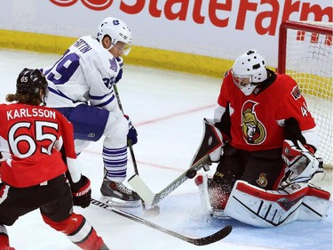 Ottawa Senators goaltender Craig Anderson makes a save on Toronto Maple Leaf forward Matt Frattin (39) as Ottawa Senators defenceman Erik Karlsson (65) looks on during first period NHL pre-season hockey action in Ottawa on Wednesday, September 24, 2014.