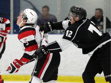 Olympiques' Mickael Beauregard (12) cross-checks 67's Matt Mercer (5) drawing a two-minute penalty during 1st period junior hockey action at the Nepean Sportsplex in Ottawa, Saturday, September 6, 2014. The 67's won the game 4-3.