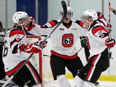 Ottawa 67's players (L2R) Jonathan Dushesne, Dylan McDonald and Ben Fanjoy celebrate a first period goal vs. Gatineau Olympiques at the Nepean Sportsplex in Ottawa, Saturday, September 6, 2014.