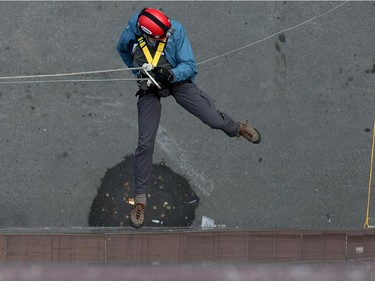 Ottawa Citizen editor Blair Crawford hangs off the rope as as participants rappel from the top of the Morguard Building at 280 Slater Street in the 5th annual Drop Zone Ottawa event which raises money for Easter Seals. September 22, 2014.