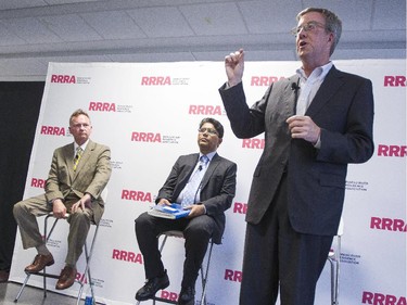 Ottawa mayor Jim Watson, right, speaks during an all-candidates mayoral debate at the Carleton University Residence Commons while candidates Mike Maguire, left, and Anwar Syed, centre, look on Tuesday September 23, 2014.