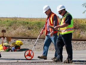 OTTAWA, ON: SEPTEMBER 28, 2013 - Transportation Safety Board investigators take measurments on the Transitway near Fallowfield Station in Barrhaven (Ottawa) on Saturday, September 28, 2013. The Transportation Safety Board (TSB) and Ottawa police returned to the scene, running parallel follow-up investigations in similar conditions to that fateful morning of Wednesday, Sept 18, 2013 when an OC Transpo double decker bus slammed into a VIA Rail train. Six people were killed. (photo by Mike Carroccetto / Ottawa Citizen)��� (for WEB / CITY story by by STANDALONE) NEG# 114599