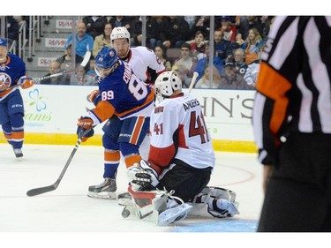 Ottawa Senators goaltender Craig Anderson makes a save as N.Y. Islanders Cory Conagher (89) and Sens Mark Stone (61) watch the play suring pre-season NHL action in St. John's, N.L. on Monday September 22, 2014.