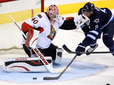 Ottawa Senators goaltender Robin Lehner (40) shoves Winnipeg Jets' Evander Kane (9) as he tries to get a shot away during first period pre-season NHL hockey action in Winnipeg, Tuesday, September 30, 2014.