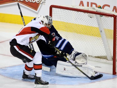Ottawa Senators' Zack Smith (15) is stopped by Winnipeg Jets goaltender Ondrej Pavelec (31) during third period pre-season NHL hockey action in Winnipeg on Tuesday, September 30, 2014.