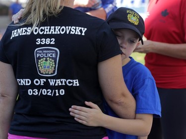 Owen Ochakovsky hugs his mom Erin on Elgin St. near Catherine St. before National Peace Officers Memorial Run to Remember runners arrive in downtown Ottawa, Saturday, September 27, 2014. Erin, who lost her husband James in an on-duty car crash in 2010, and Owen, joined police officers for the final leg past Ottawa Police headquarters then up Elgin to Parliament Hill.