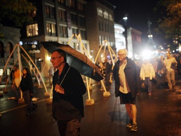 People endure the rain and roam on George St. during Nuit Blanche in Ottawa, on Saturday, September 20, 2014.