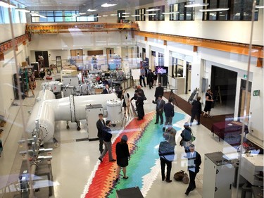 People mingle amongst the newly acquired Accelerator Mass Spectrometer at the University of Ottawa's Advanced Research Complex on September 30, 2014 during the official opening.