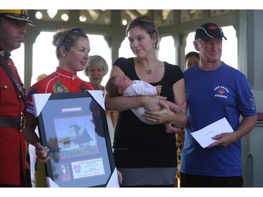 RCMP Const. Ross' widow holds their baby during a National Peace Officers Memorial Run ceremony and presentation behind Parliament Hill in Ottawa, Saturday, September 27, 2014. Police officers ran 460km from Toronto to Ottawa.