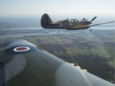 Rob Erdos flies the P40 Kittyhawk as Michael Potter pilots the P-51 Mustang, as they escort the Canadian Warplane Heritage Museum's Avro Lancaster to Vintage Wings of Canada in Gatineau, Sept. 27, 2014.
