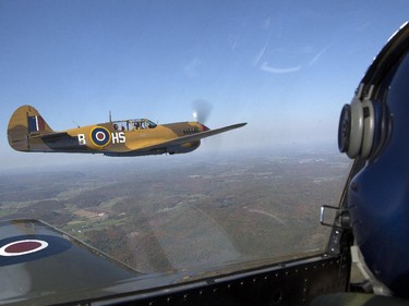 Rob Erdos flies the P40 Kittyhawk, left, as Michael Potter pilots the P-51 Mustang, right, as they escort the Canadian Warplane Heritage Museum's Avro Lancaster to Vintage Wings of Canada in Gatineau, Sept. 27, 2014.