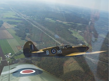 Rob Erdos flies the P40 Kittyhawk, left, as Michael Potter pilots the P-51 Mustang, right, as they escort the Canadian Warplane Heritage Museum's Avro Lancaster to Vintage Wings of Canada in Gatineau, Sept. 27, 2014.