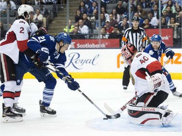 Toronto Maple Leafs forward James van Riemsdyk, centre, gets stopped by Ottawa Senators goalie Robin Lehner, right, as Senators defenceman Jared Cowen, left, battles for the puck during second period pre-season NHL hockey action in Toronto on Wednesday, September 24, 2014.